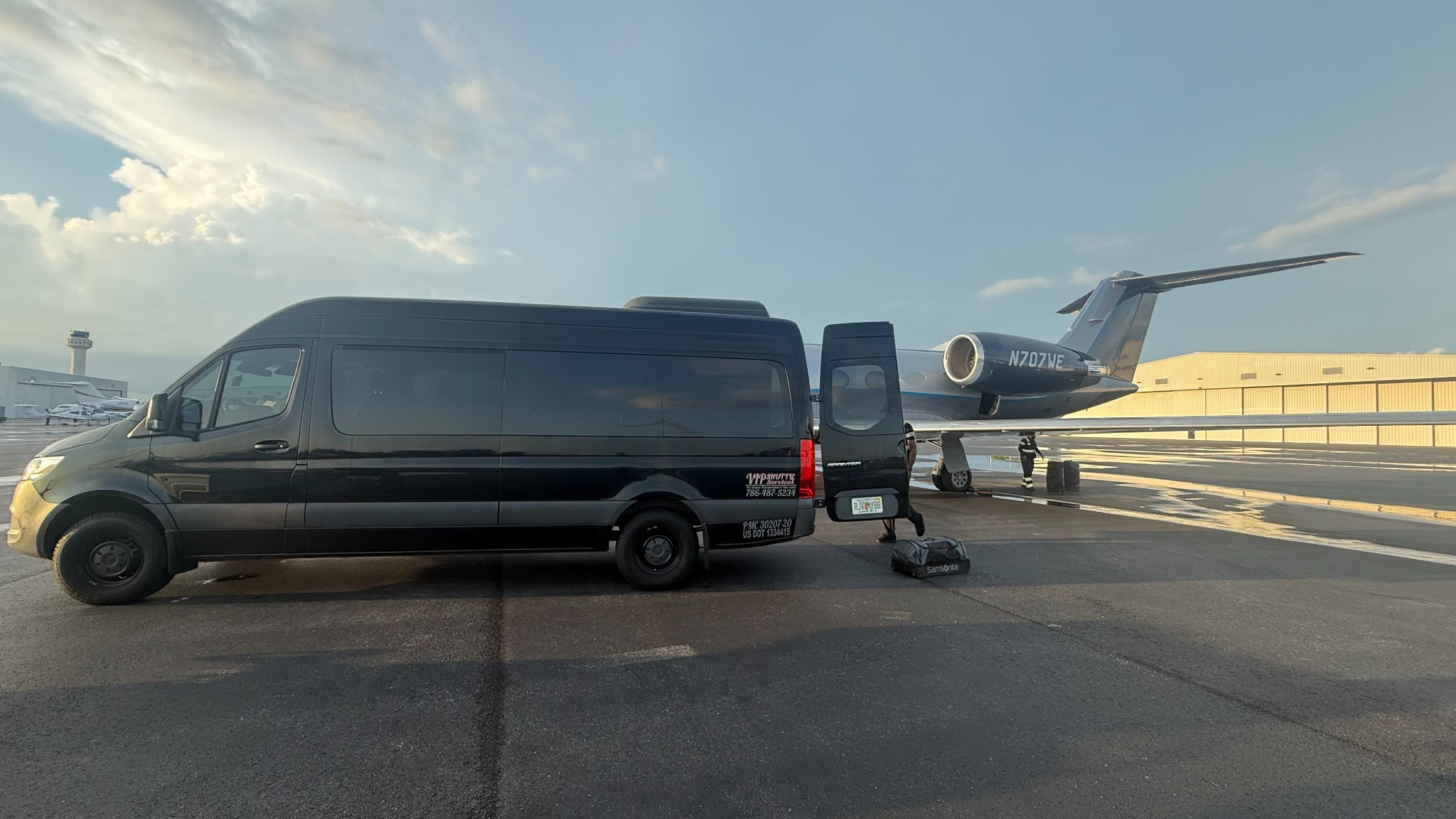 VIP Shuttle Services black Sprinter beside a private aircraft